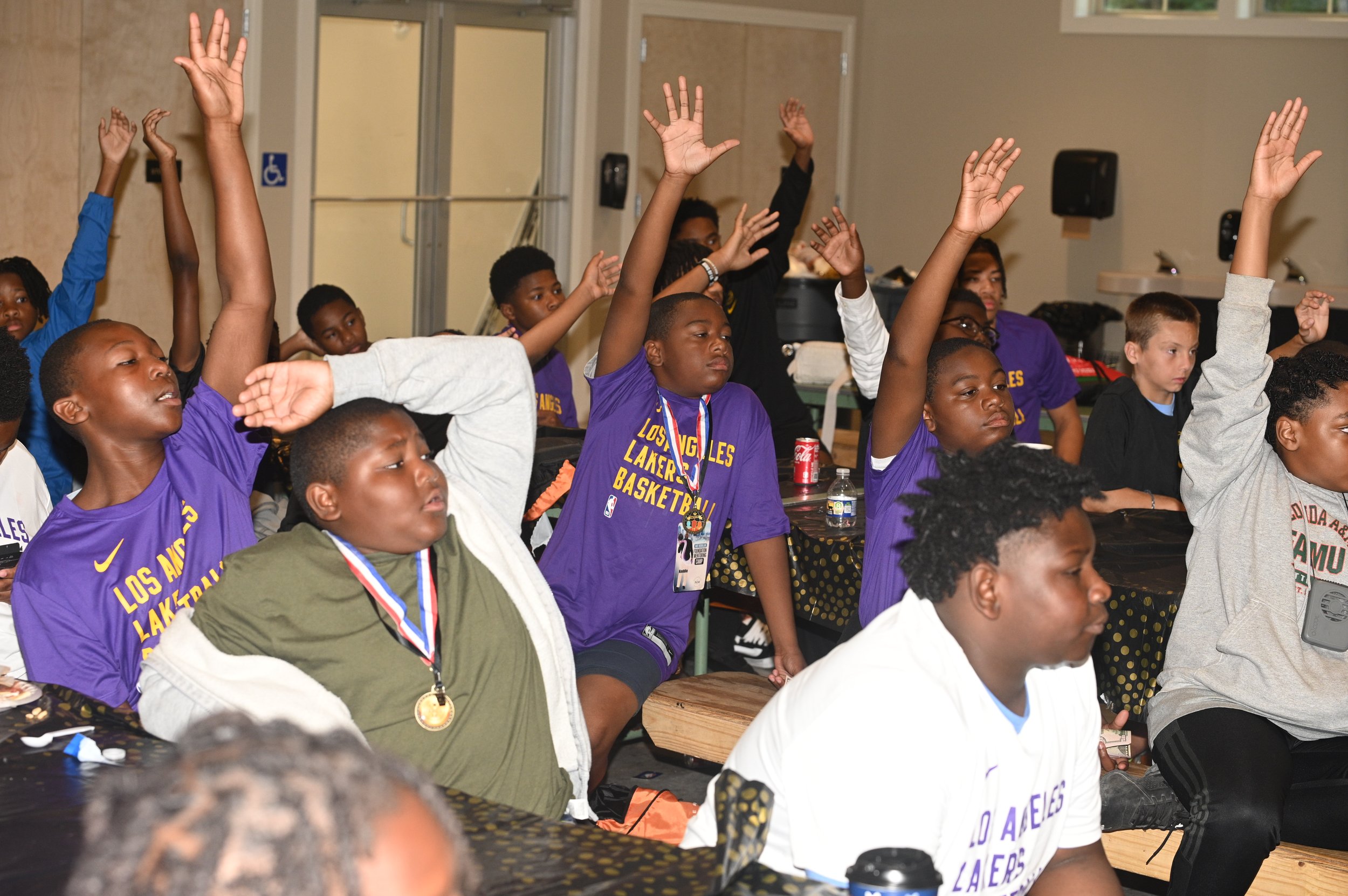 Campers raising their hands during a Mentoring Camp session